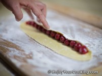 Arrange pitted cherries in line on the dough sheet
